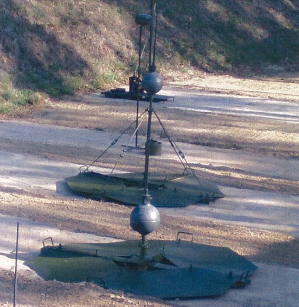 Міни ПДМ-2, підготовлені до установки, на низькій підставці (на передньому плані) та на високій підставці (на задньому плані).